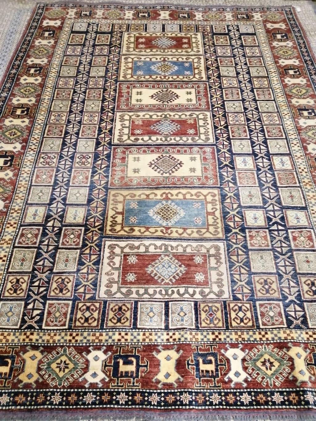 An Afghan Kazak blue, red and ivory ground rug with all-over stylised motifs, 294 x 216cm